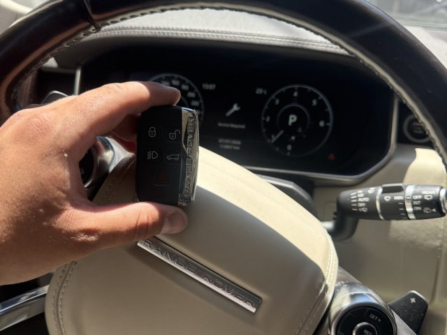 Range Rover key fob held over the steering wheel of a Range Rover