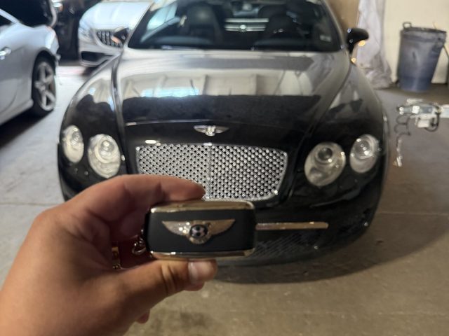 Black Bentley in a Vancouver garage with a hand holding its key fob