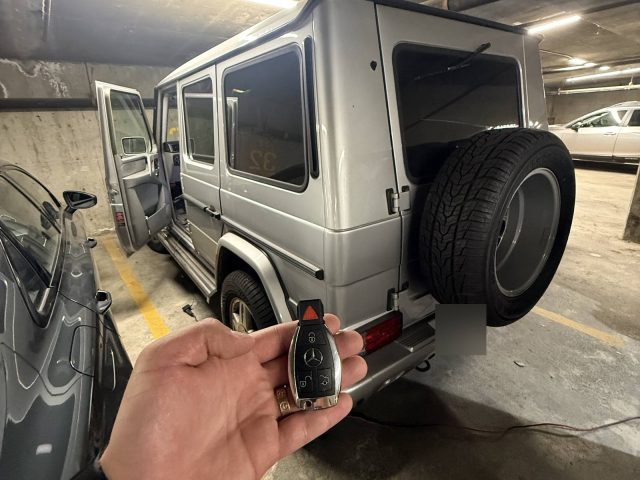 Silver Mercedes-Benz G-Class in a Vancouver parkade with a hand holding its key fob